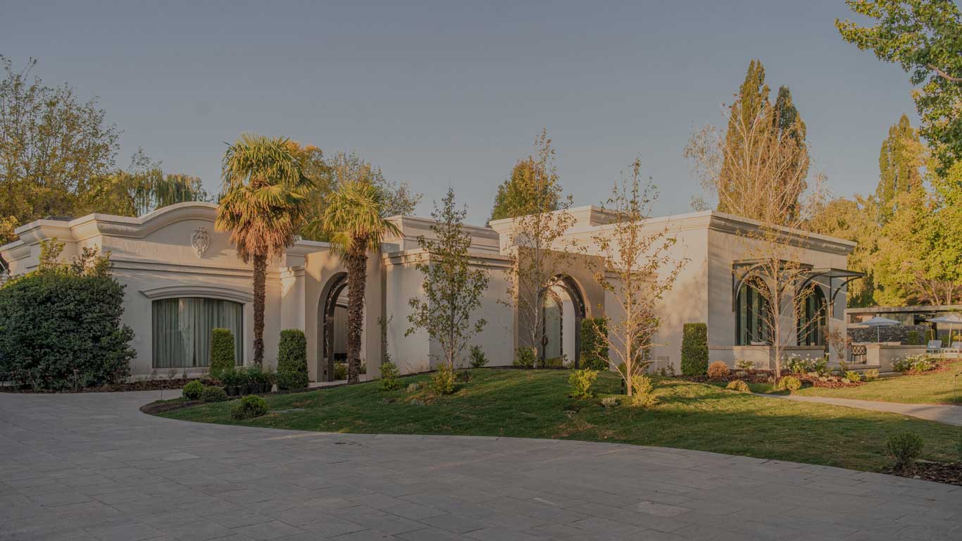 Imagem da vinícola Susana Balbo, em Chacras de Coria, um excelente lugar onde ficar em Mendoza, Argentina. A construção se destaca em meio a belos jardins.