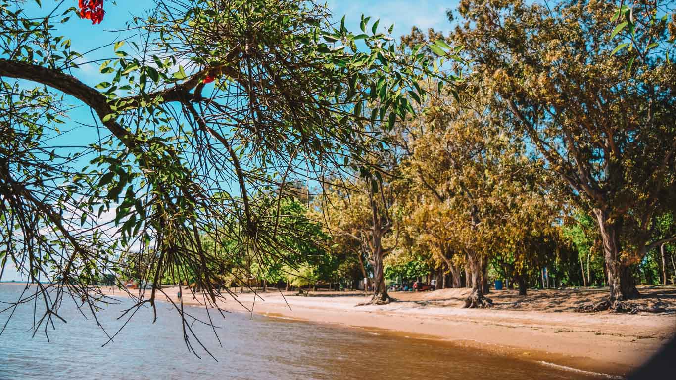 Imagem de uma praia de Carmelo, cercada por uma exuberante paisagem natural.