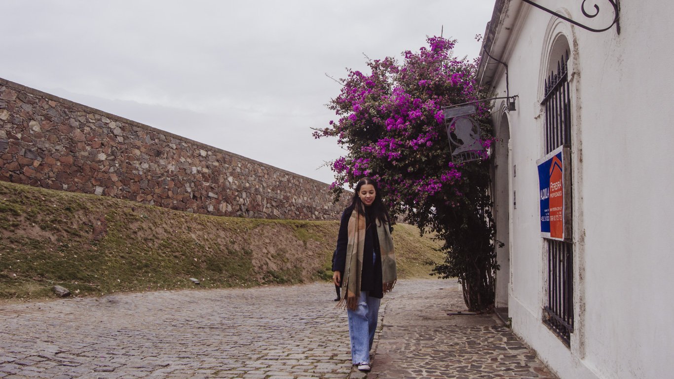 Mulher caminhando pelas ruas de paralelepípedos do Centro Histórico de Colonia del Sacramento.