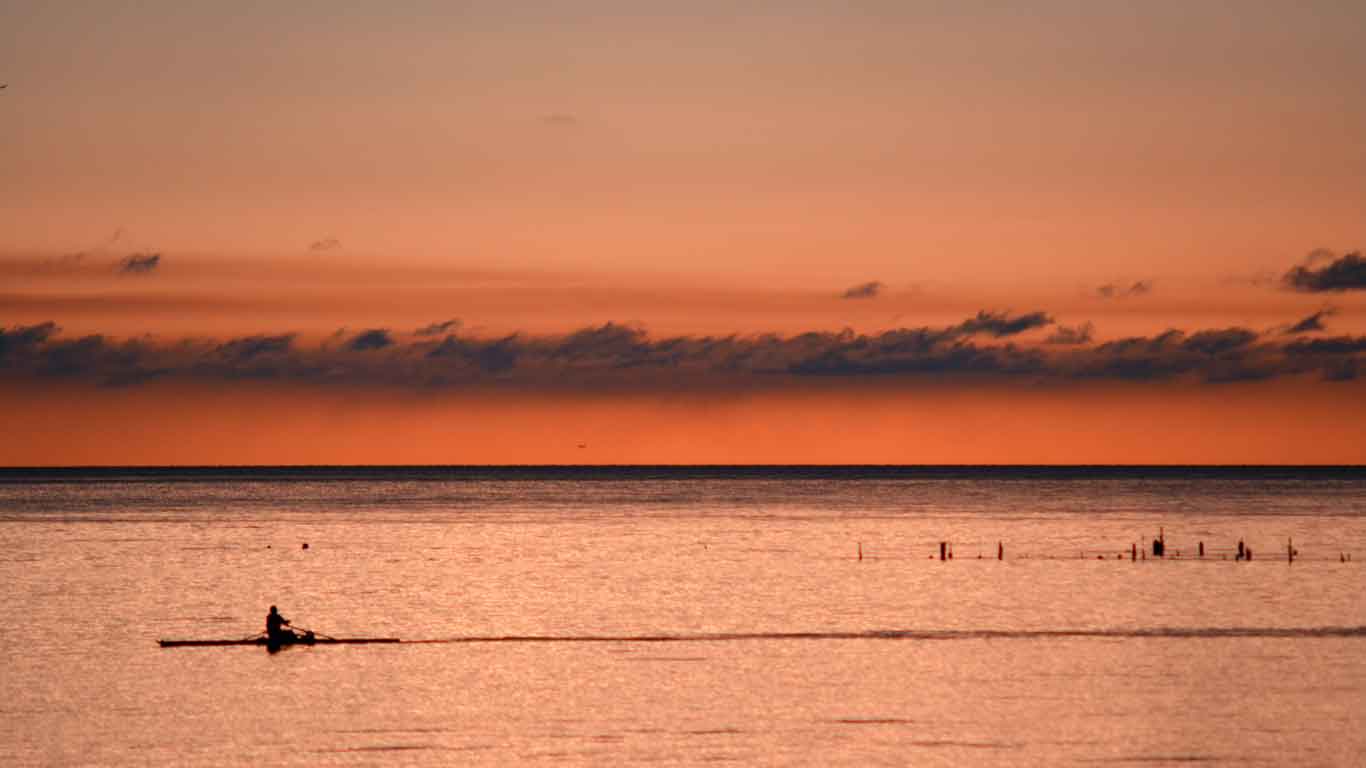 Imagem do pôr do sol em Colonia del Sacramento, acentuado pelas tonalidades alaranjadas que pintam o céu e criam um espetáculo visual deslumbrante no Río de la Plata. Ver o pôr do sol é uma melhores coisas para fazer em Colonia del Sacramento.