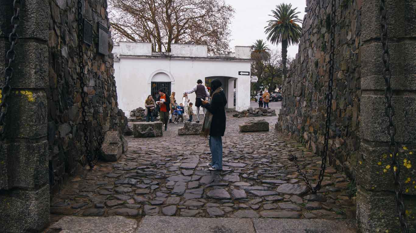 Mulher atravessando o Portón de Campo em Colonia del Sacramento.