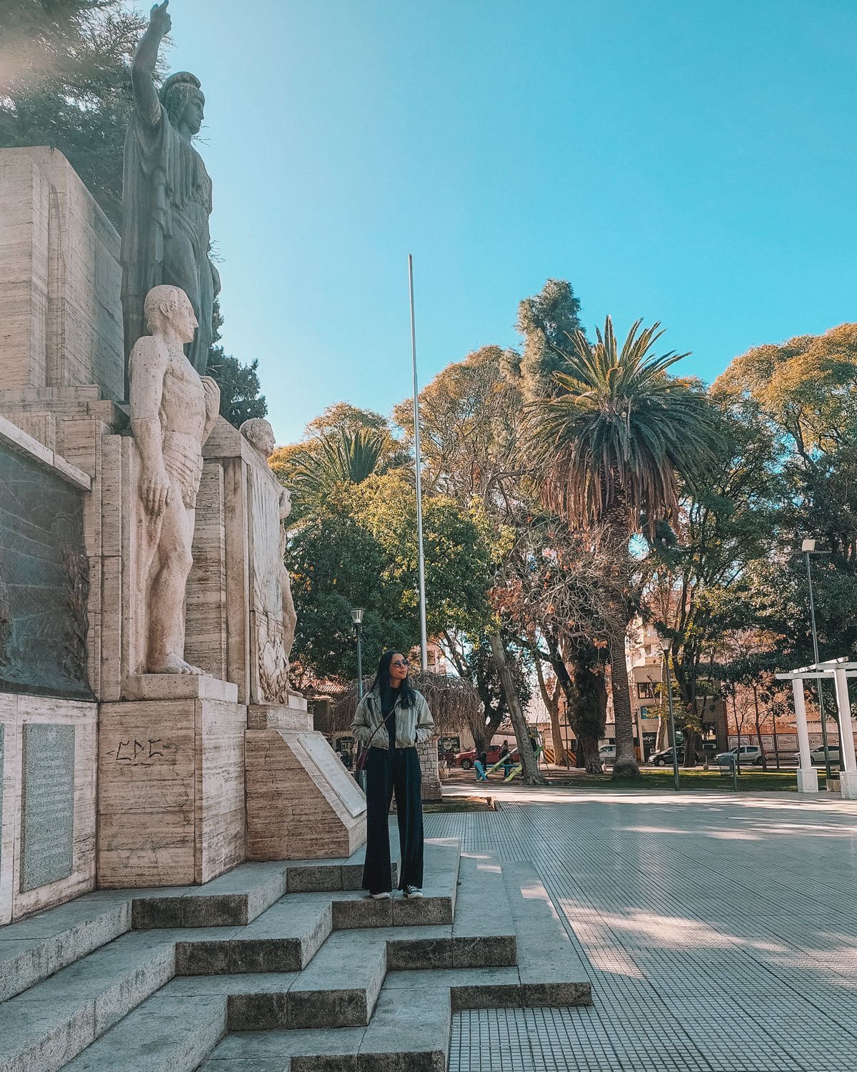 Uma mulher posando ara uma foto em uma Praça no Centro de Mendoza, o melhor lugar para se hospedar.