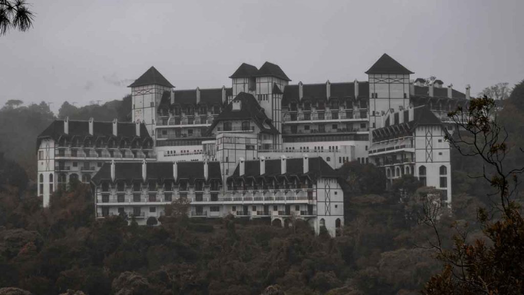 Campos do Jordão em um dia nublado do mês de agosto, com um hotel de arquitetura tradicional ao fundo.