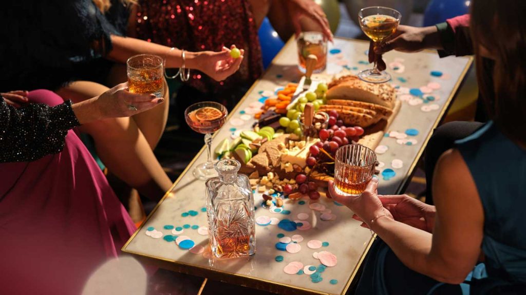 Uma mesa com a ceia de Natal servida e pessoas brindando.