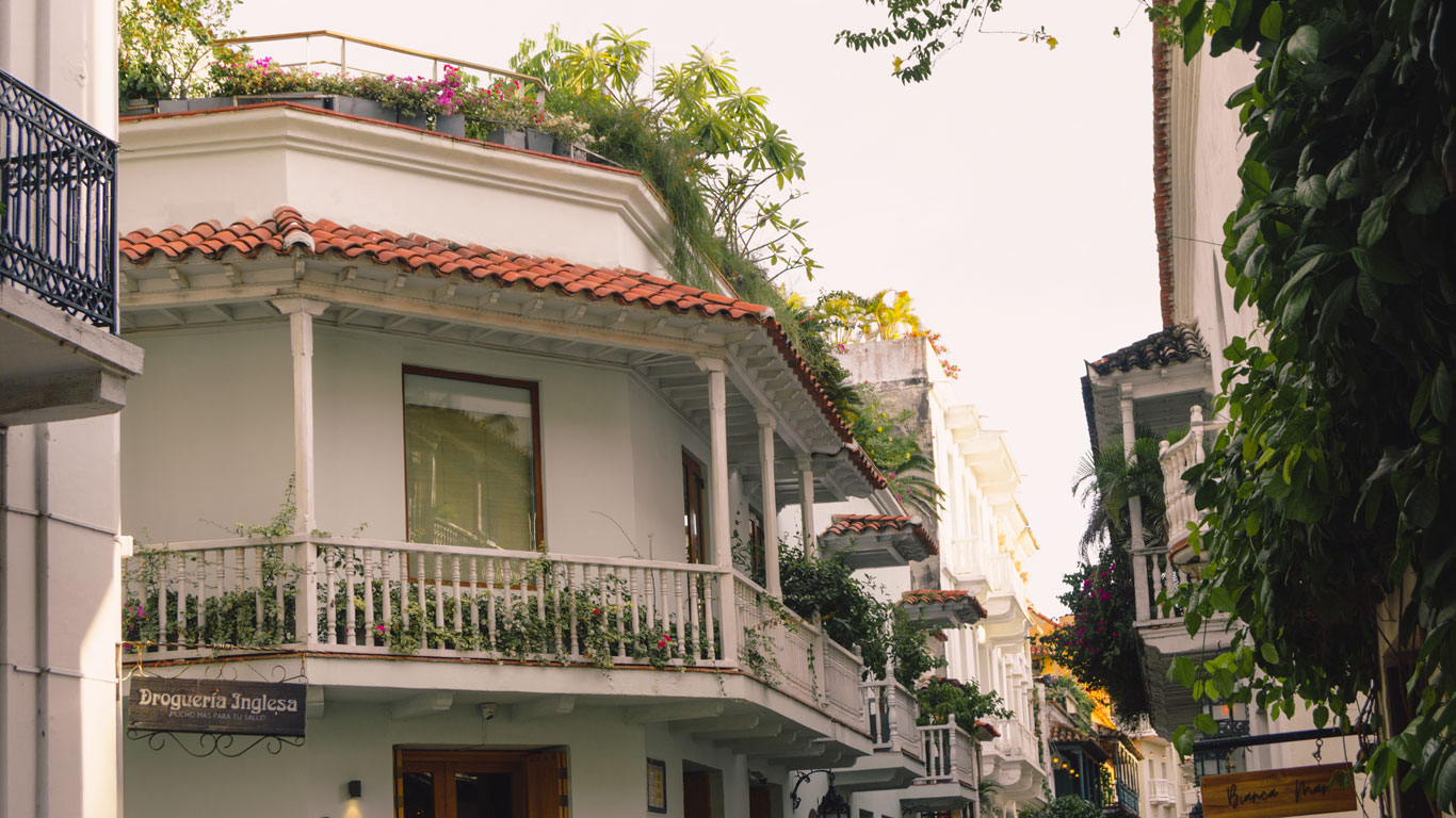 Casas coloridas com varadas cheias de plantas verdes, na Ciudad Vieja, a região mais comoda para se hospedar em Cartagena.