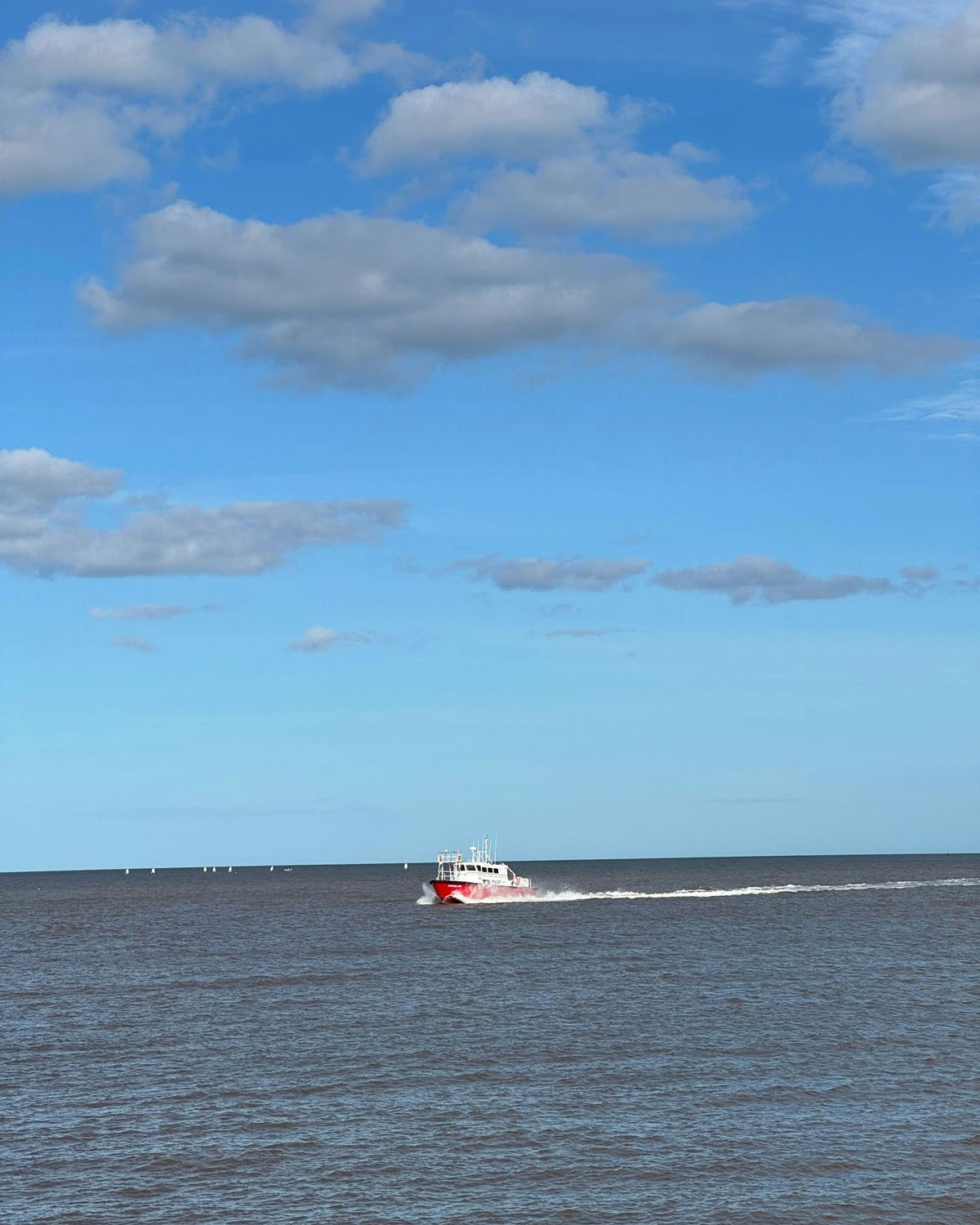 Imagem do Río de la Plata, banhado o bairro de Punta Carretas em Montevidéu, com alguns barcos navegando em um dia ensolarado.