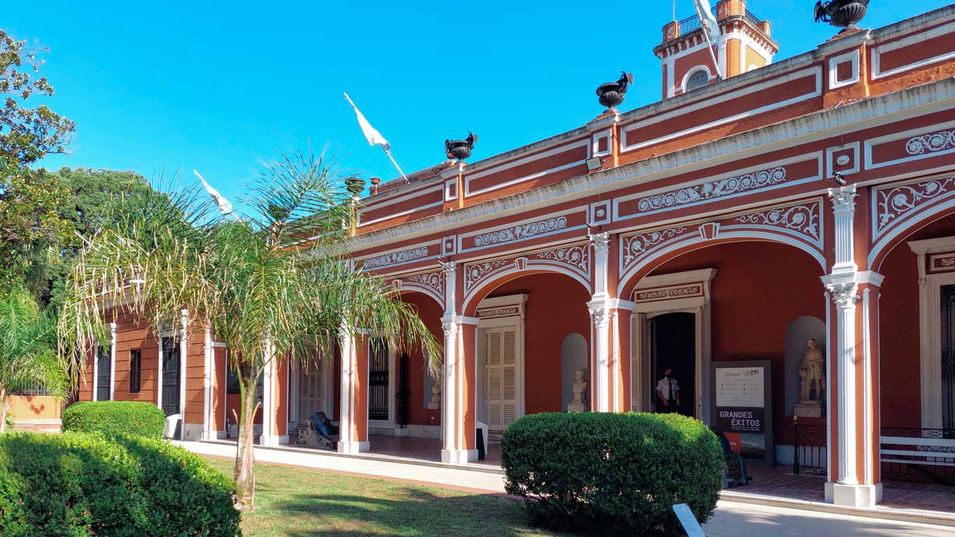 Fachada do Museu Histórico Nacional da Argentina, em Buenos Aires. O edifício é adornado por arcos decorativos brancos e detalhes ornamentados, com colunas clássicas que emolduram a entrada.