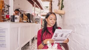 Mulher lendo um cardápio em espanhol em Jericó, na Colômbia, como parte da imersão cultural do intercambio de espanhol.