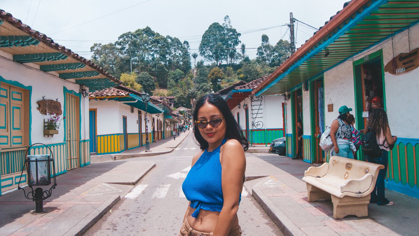 Mulher posando para a foto nas ruas coloridas de Salento, na Colômbia.