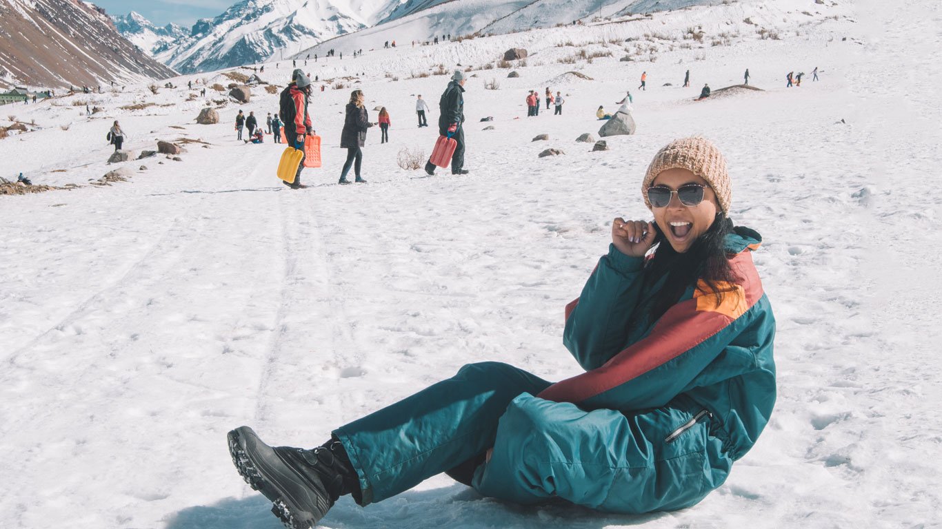 neve na argentina Mulher com um macacão de neve azul se divertindo na neve em Mendoza, um dos melhores destinos para ver neve na Argentina