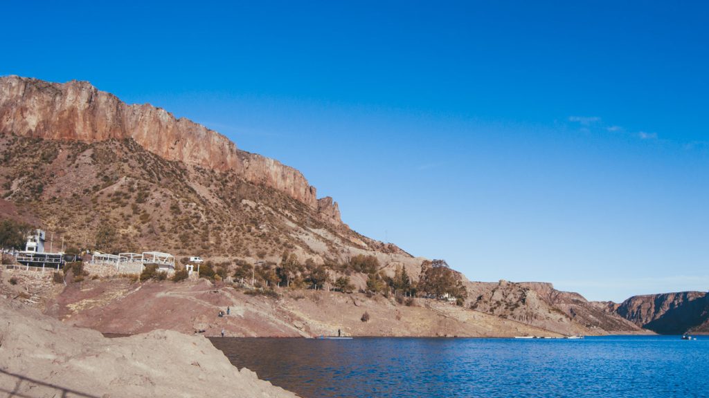 Vista panorâmica do Cañón del Atuel em San Rafael, cercado por montanhas áridas e rochosas sob um céu azul claro.