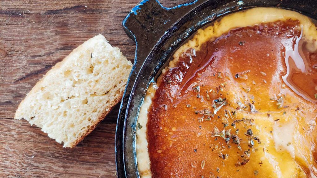 Provoleta, acompanhada de pão, servido no restaurante da bodega Tempus Alba, um dos melhores restaurante para comer em Mendoza.