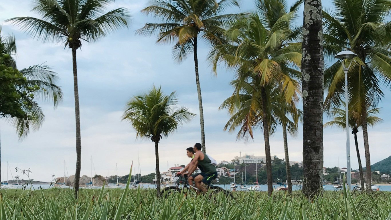 Casal andando de bicicleta na orla da Praia do Canto em Vitória.