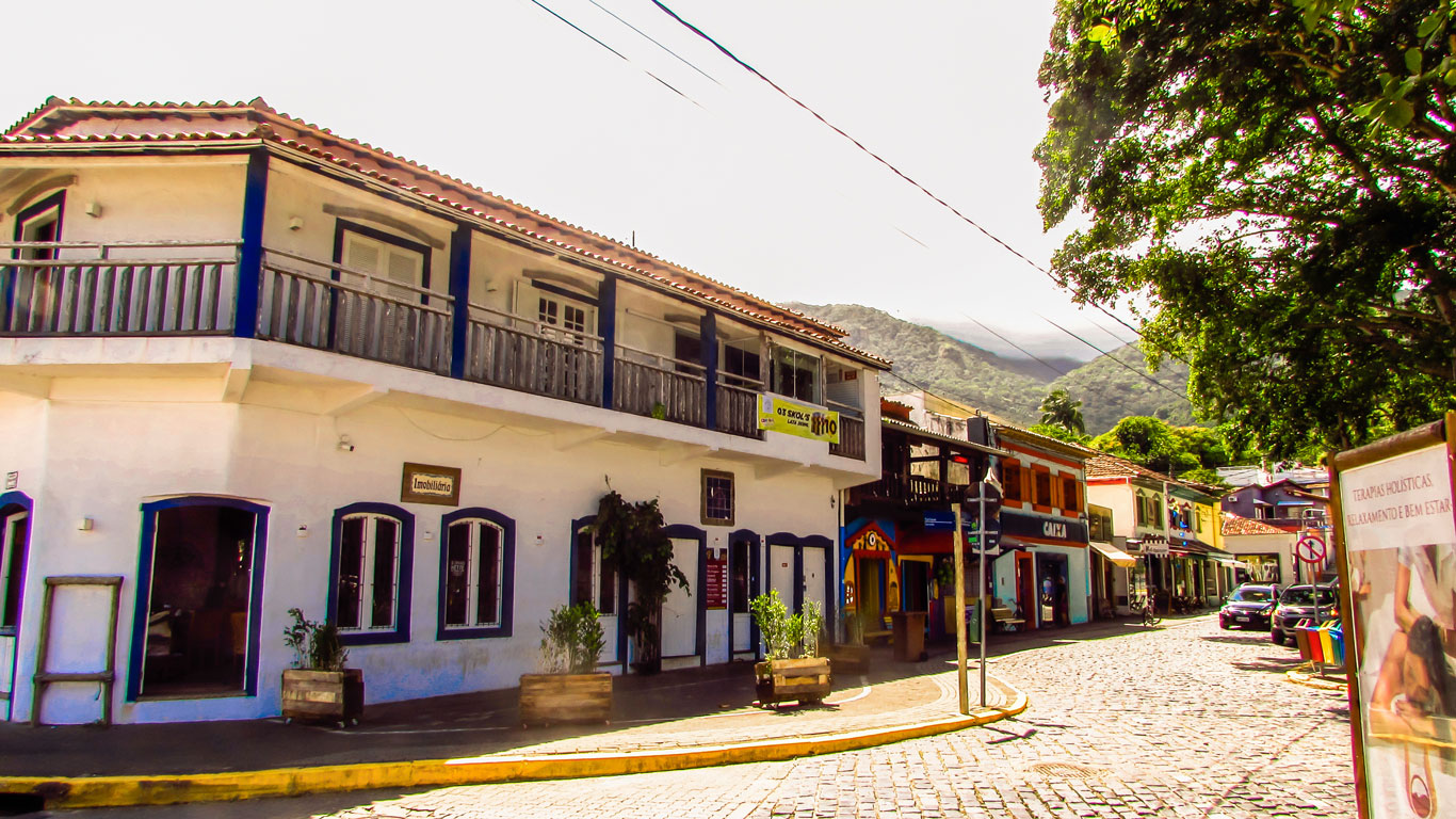 Rua de paralelepípedos no centro histórico, um dos melhores lugares onde ficar em Ilhabela, com casario colonial colorido, fachadas charmosas e varandas de madeira.